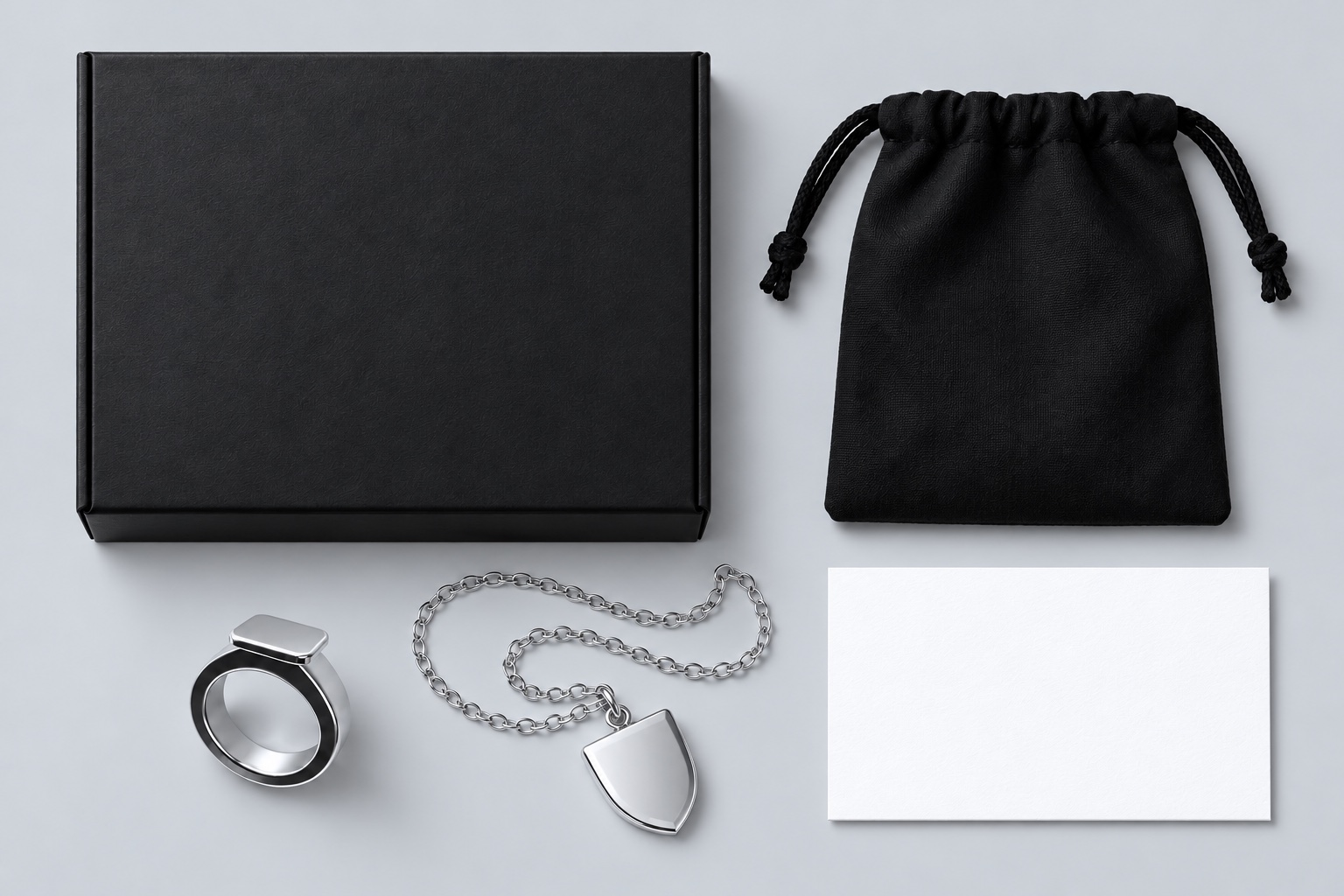 Silver jewelry with a black box, drawstring pouch and white insert card
